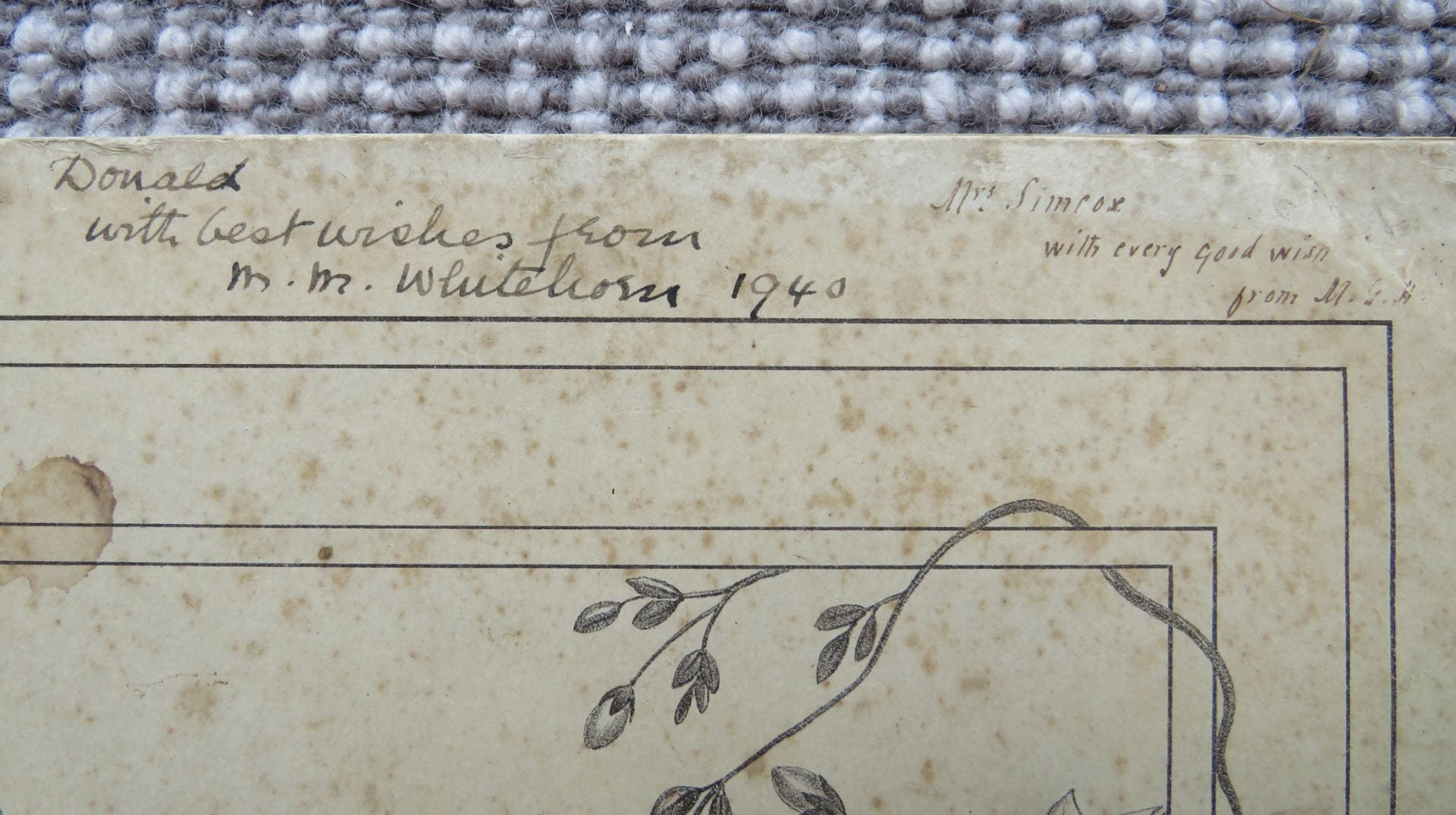 Photo of inscriptions written neatly at the top of the photographed booklet, in two different handwritings